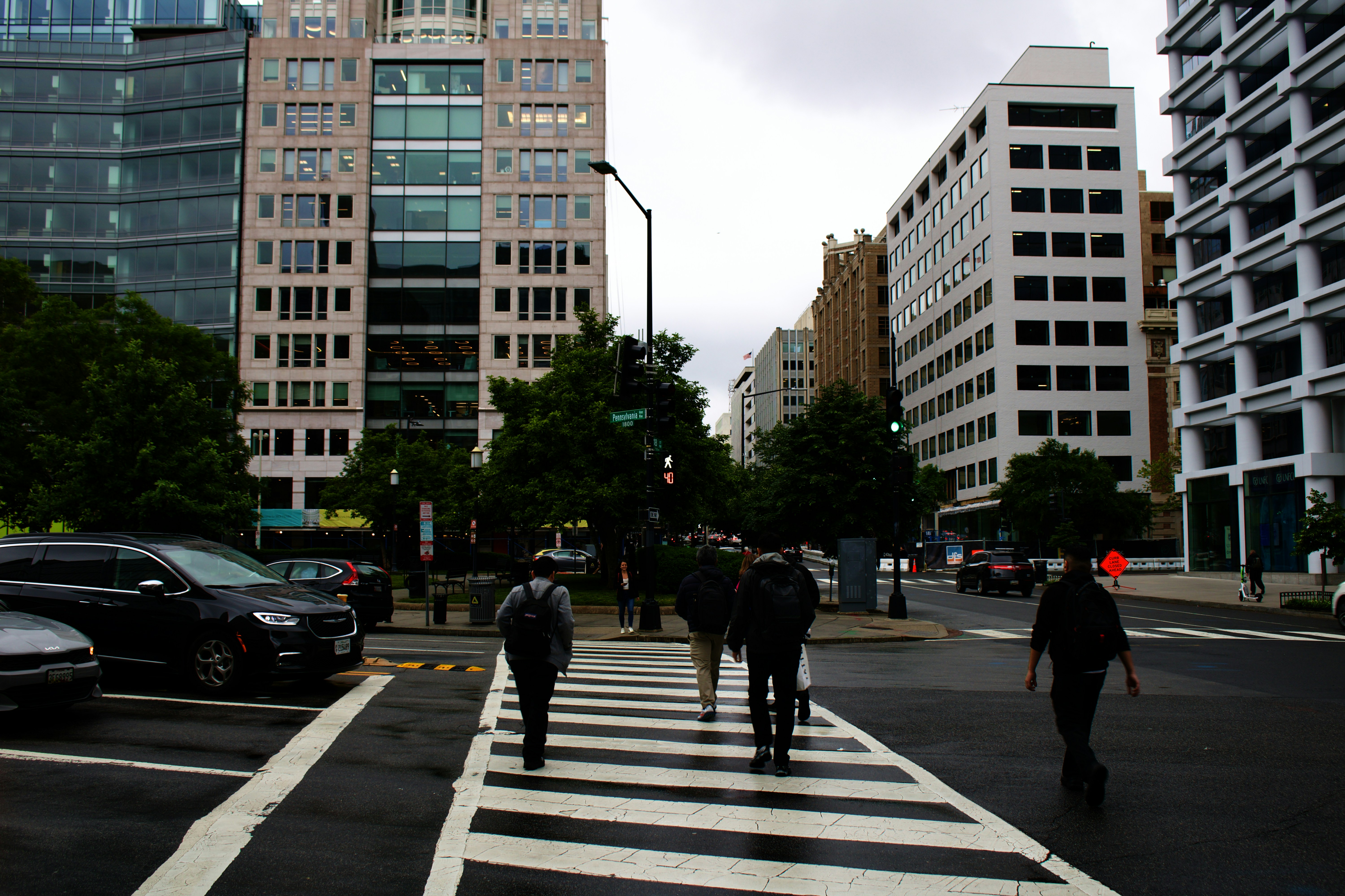 a group of people walking across a cross walk