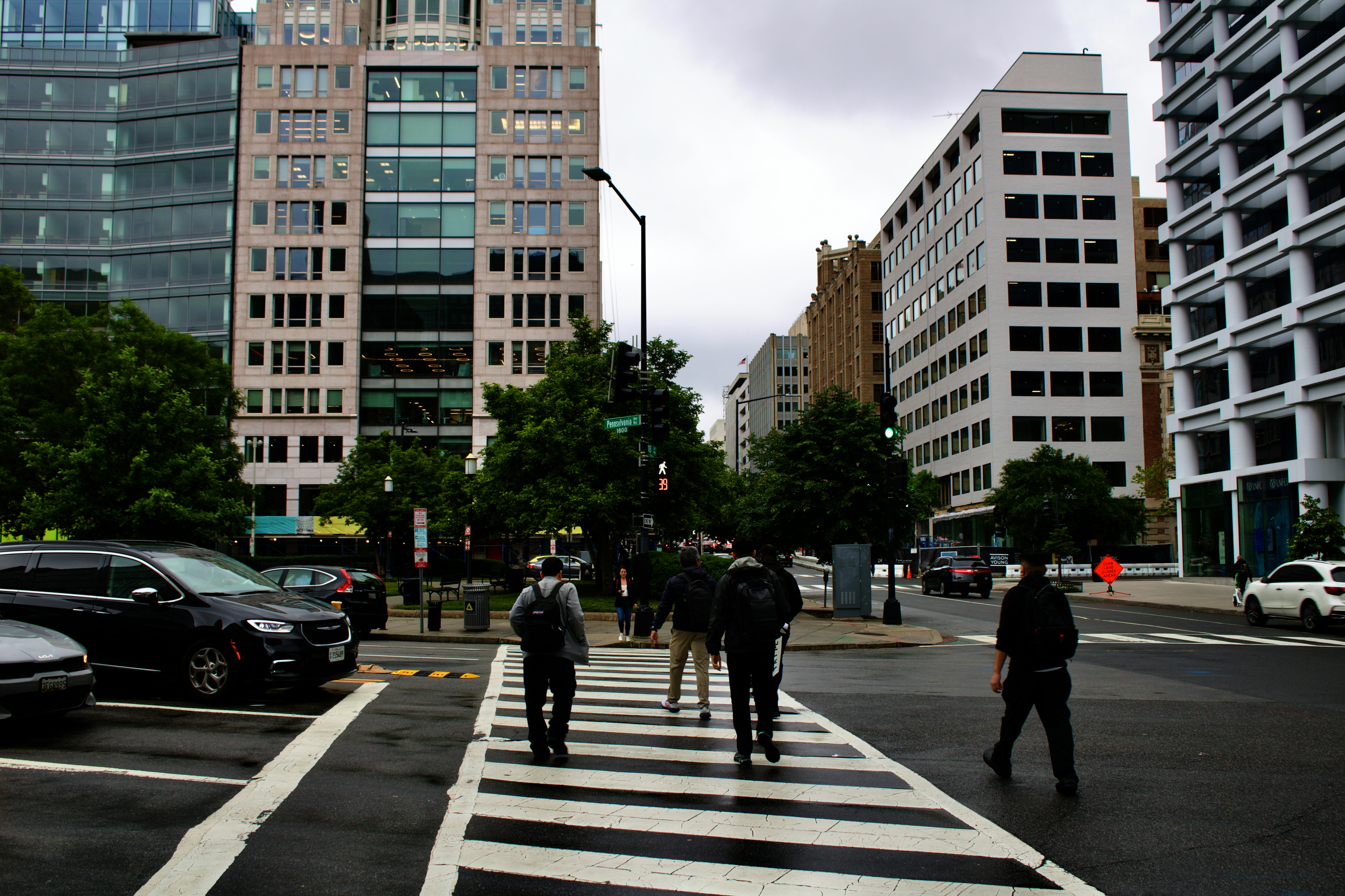 a group of people walking across a cross walk