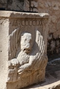 a stone statue of an angel holding a book