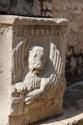 a stone statue of an angel holding a book