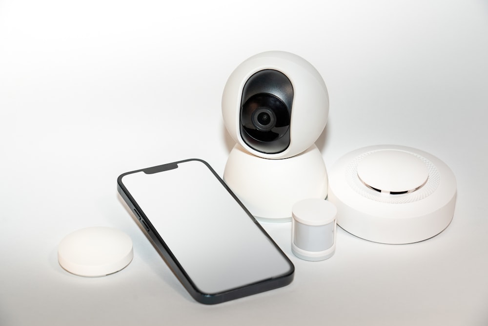 a smart phone sitting next to a security camera