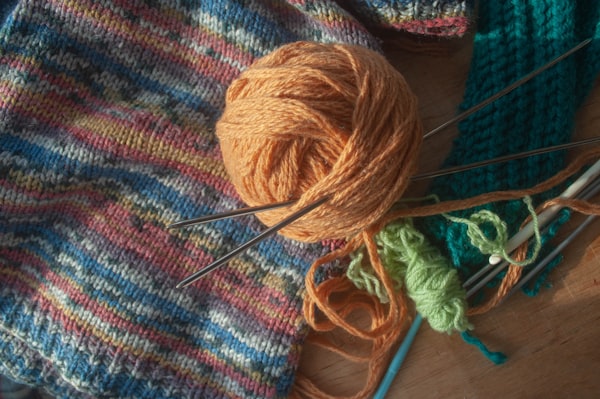 Garnknäuel und Stricknadeln auf einem Tisch