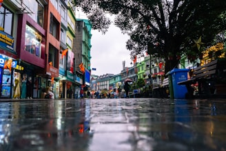 a wet street with people walking down it