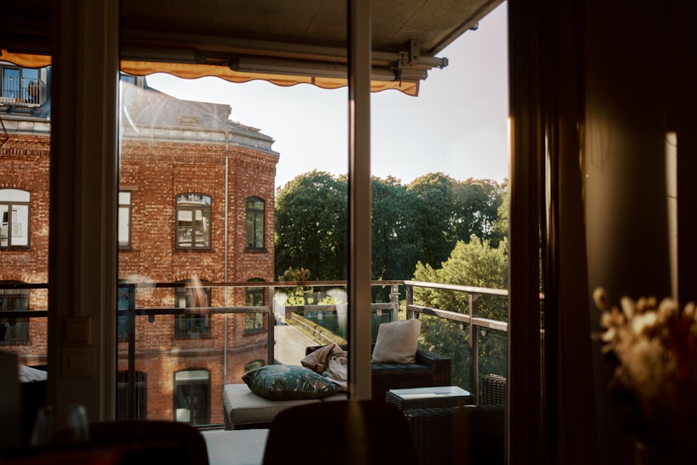 a room with a balcony and a view of a brick building