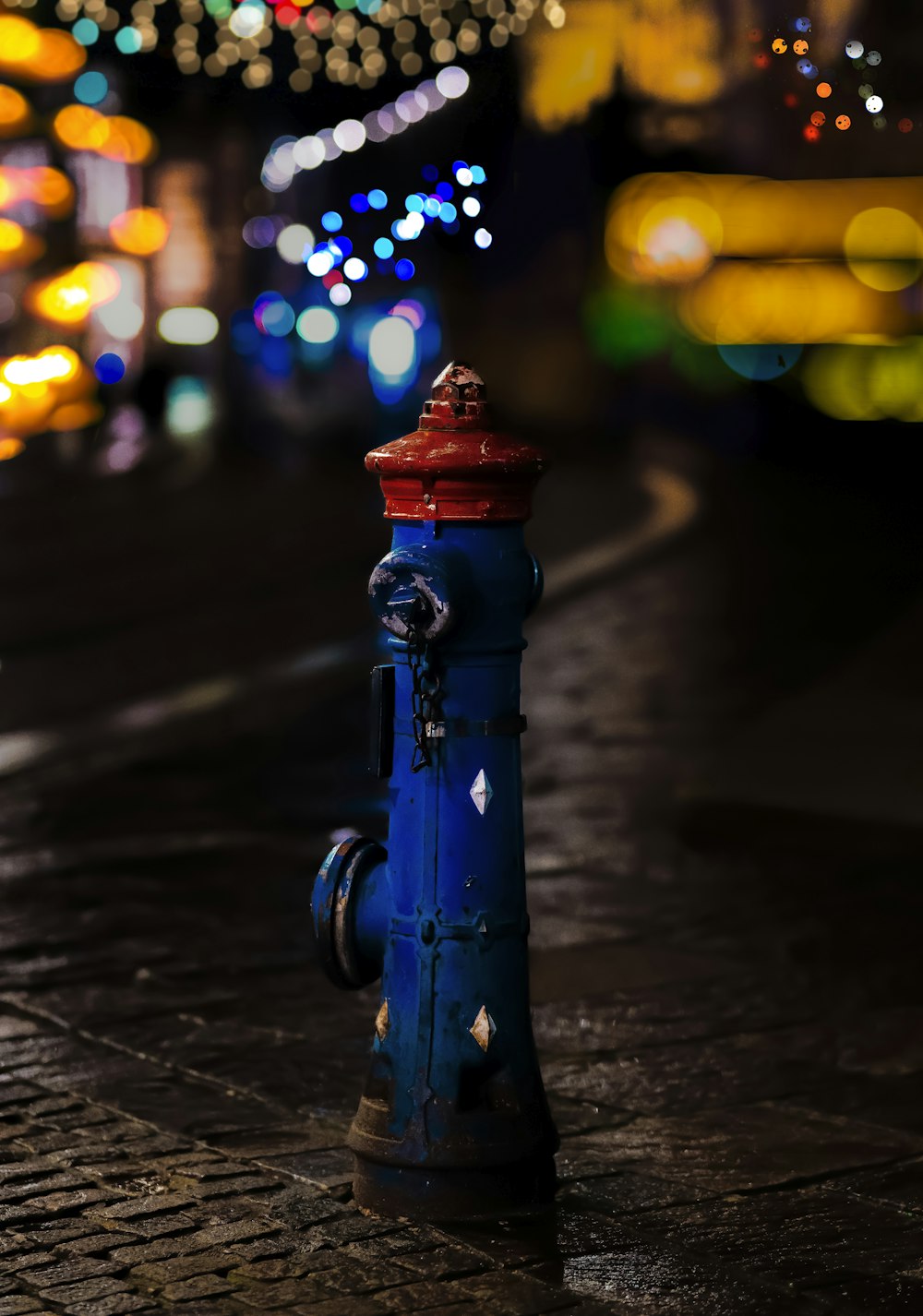 a blue fire hydrant sitting on the side of a road