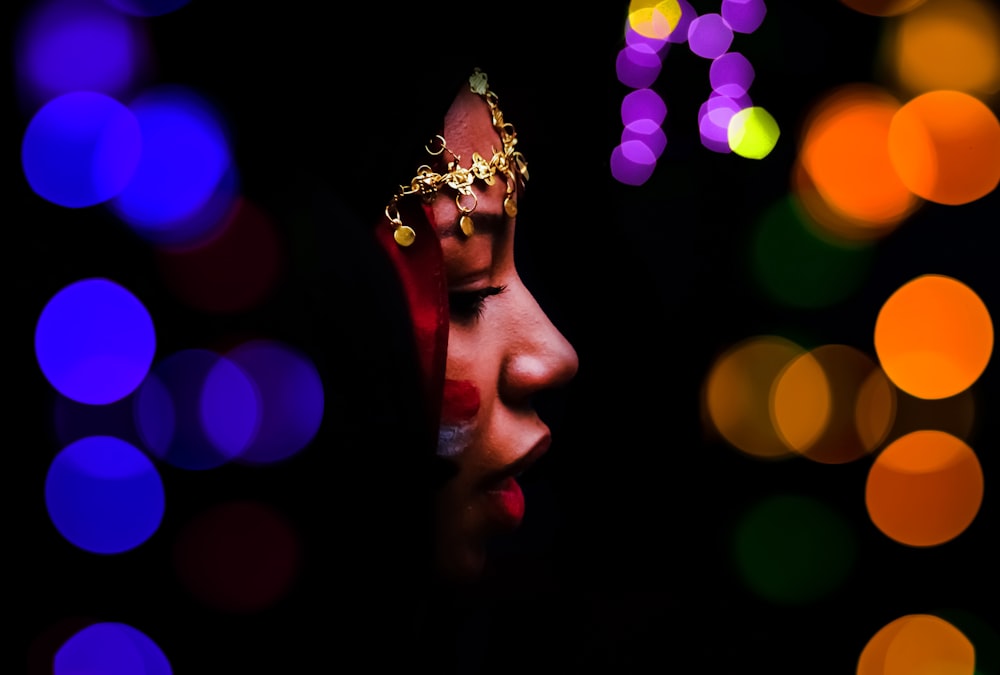 a close up of a woman's face with lights in the background