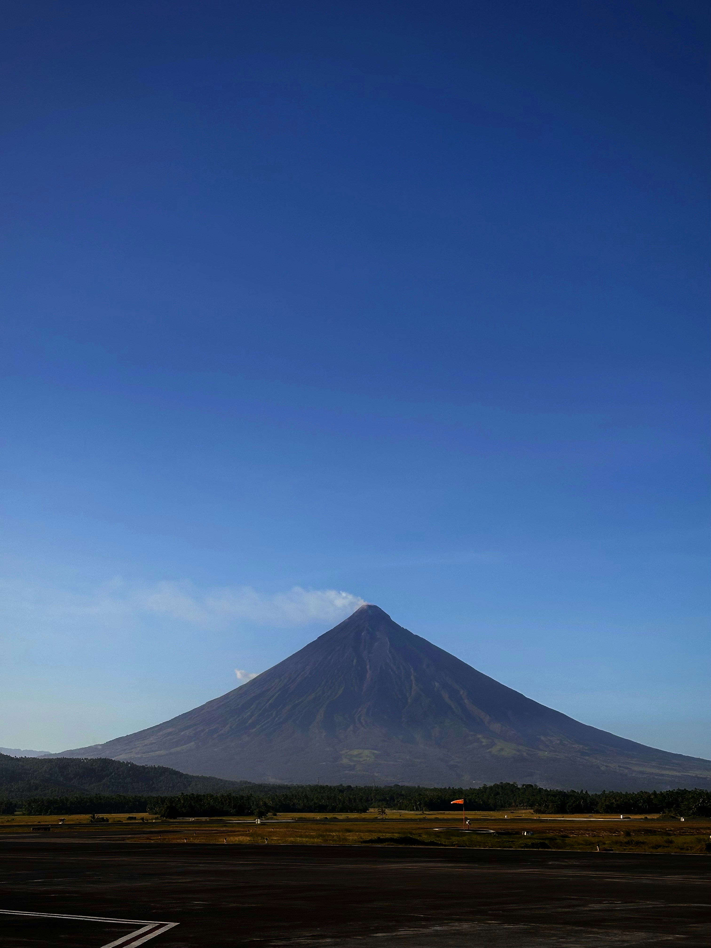 a very tall mountain towering over a small town