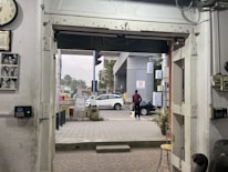 a man walking into a building with a clock on the wall