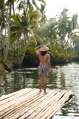a man standing on top of a bamboo raft