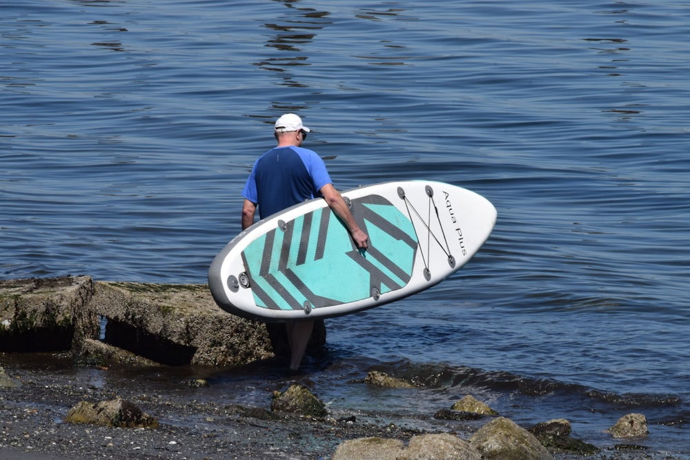 a man standing in the water holding a surfboard