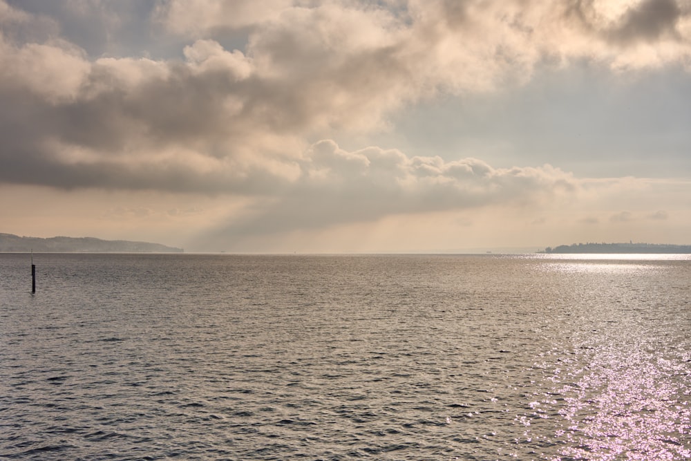 a large body of water under a cloudy sky