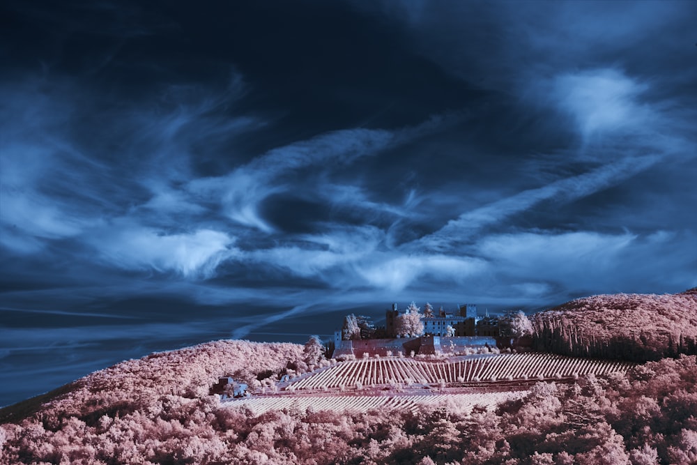 a castle on top of a hill under a cloudy sky