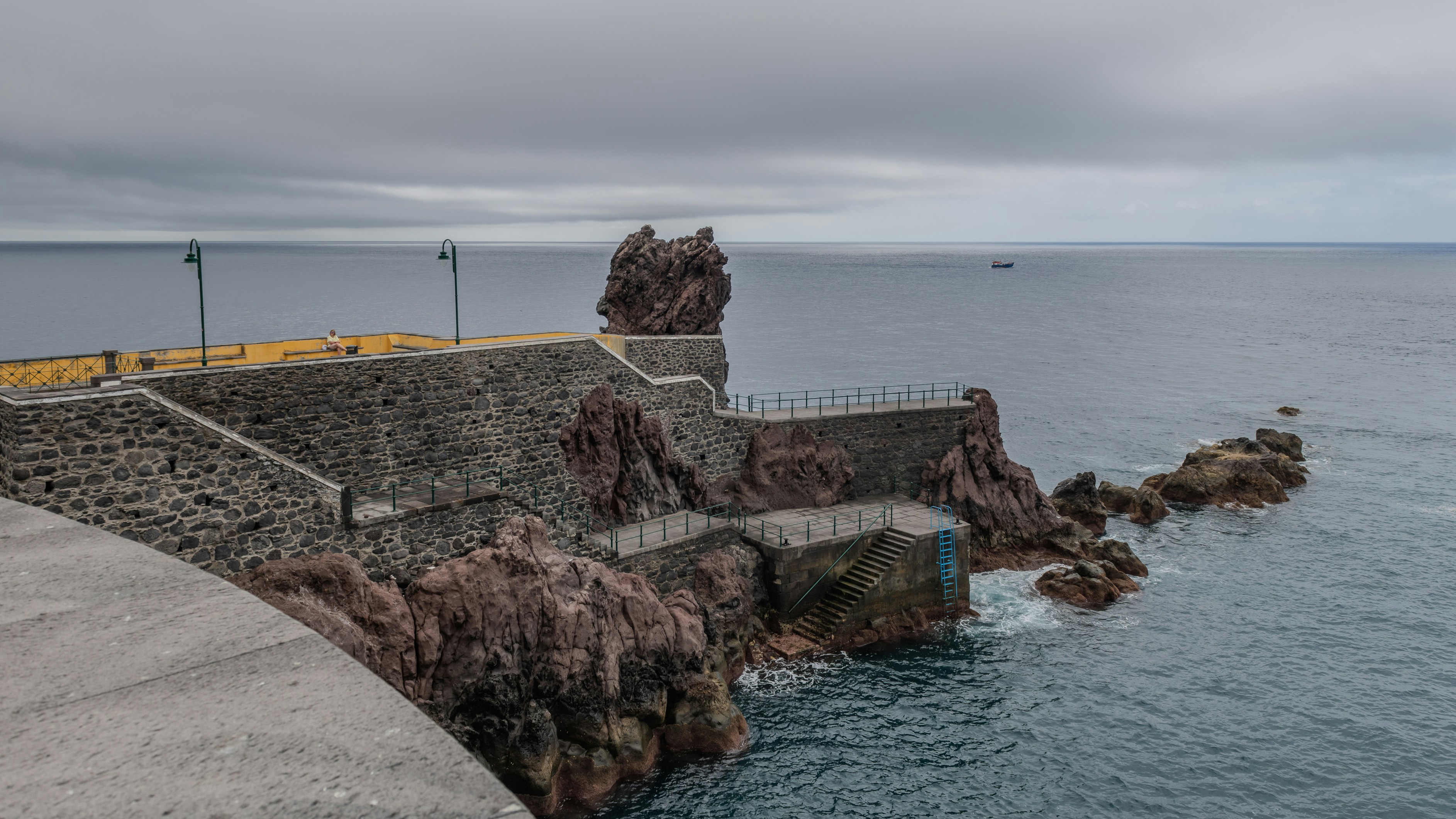 a large body of water next to a stone wall