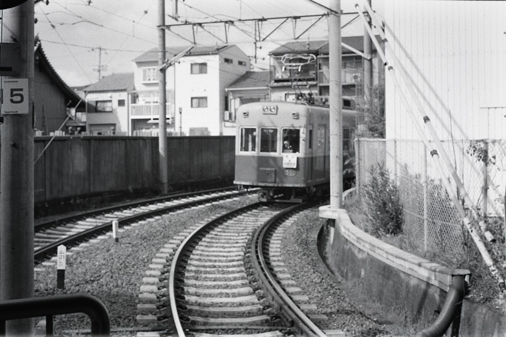 a black and white photo of a train coming down the tracks