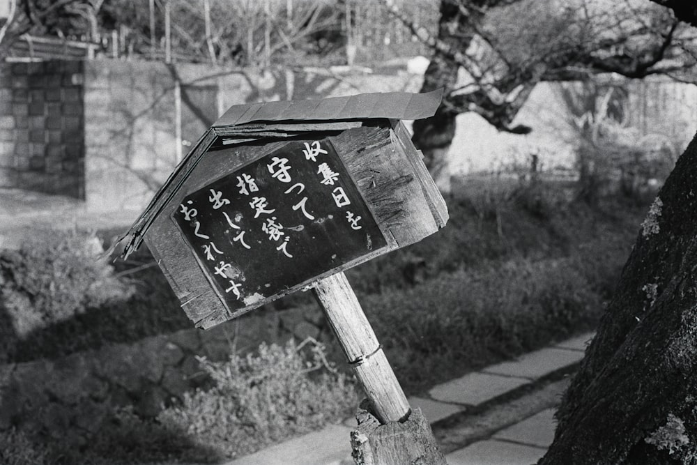 a black and white photo of a wooden sign