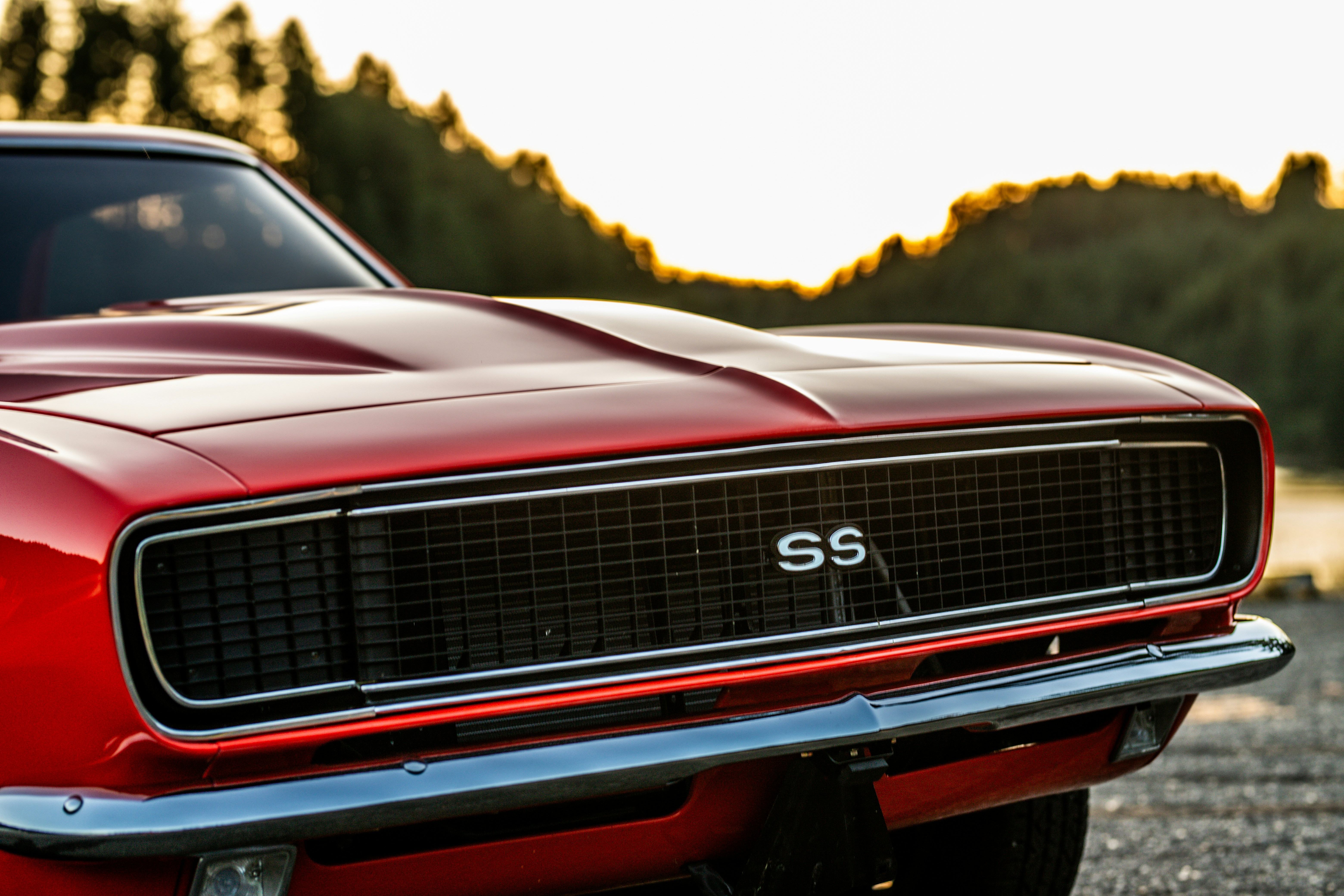 a red muscle car parked in a parking lot