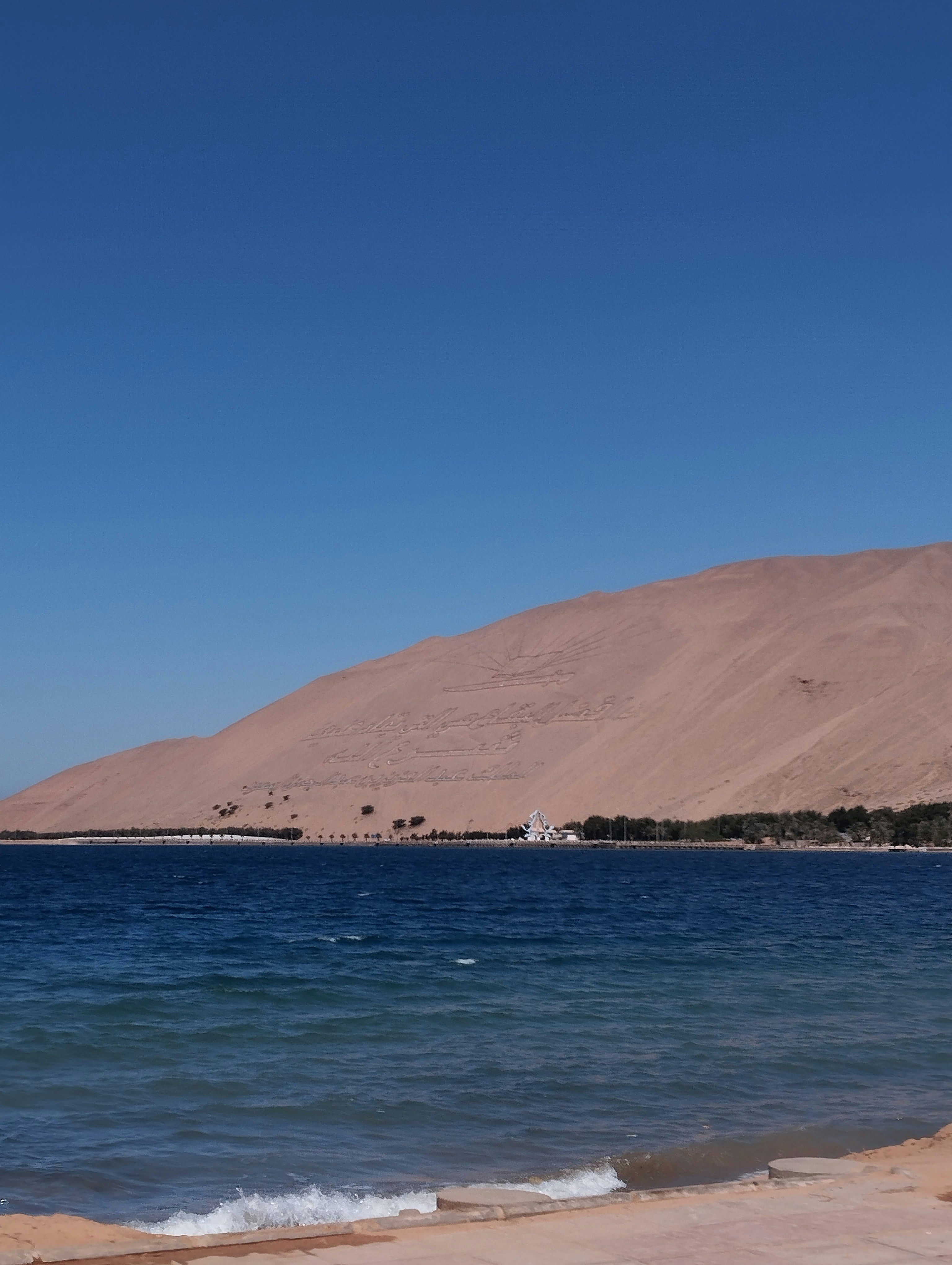 a large body of water sitting next to a sandy beach