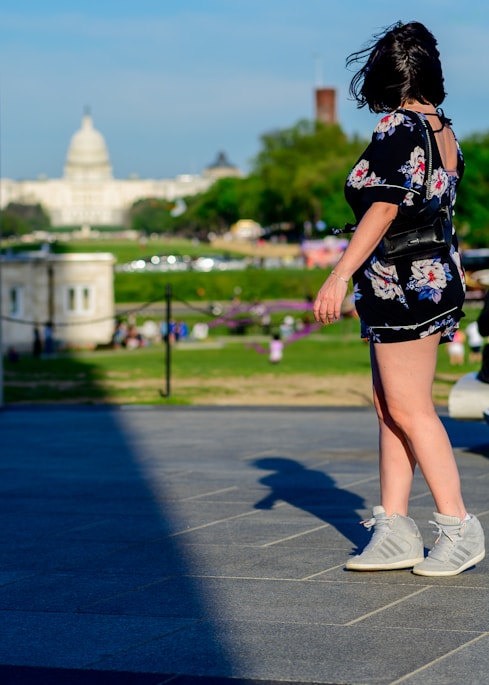 a little girl that is standing on a sidewalk