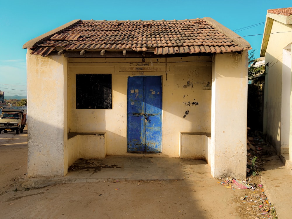 a small white building with a blue door