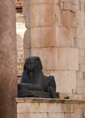 a statue of an elephant sitting on a ledge