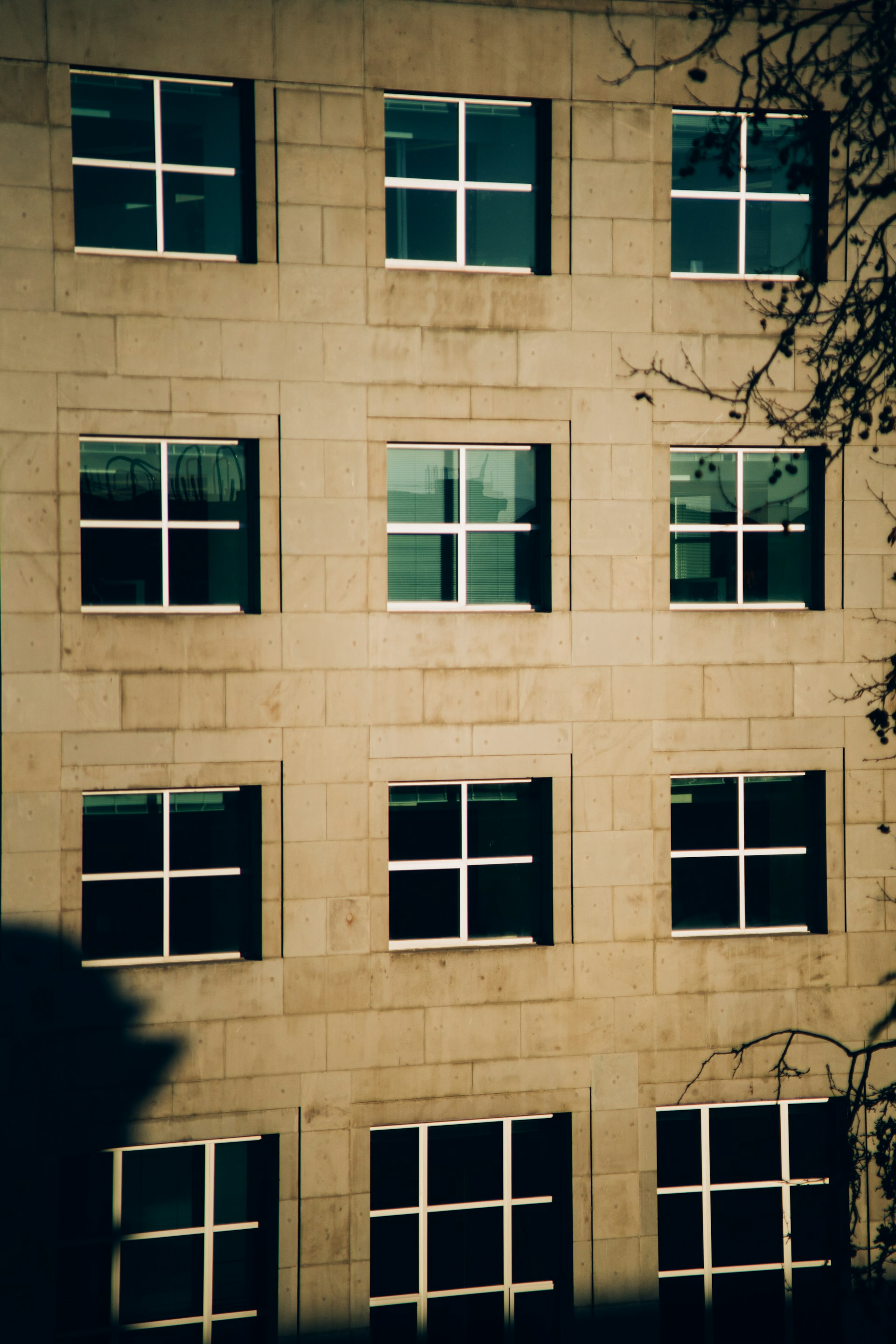 a tall building with many windows and a clock on the side of it