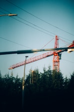 a red crane sitting on top of a building next to a traffic light