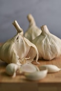 a couple of garlics sitting on top of a wooden cutting board