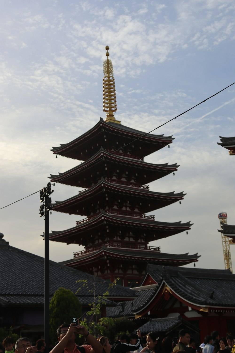 a group of people standing in front of a tall pagoda