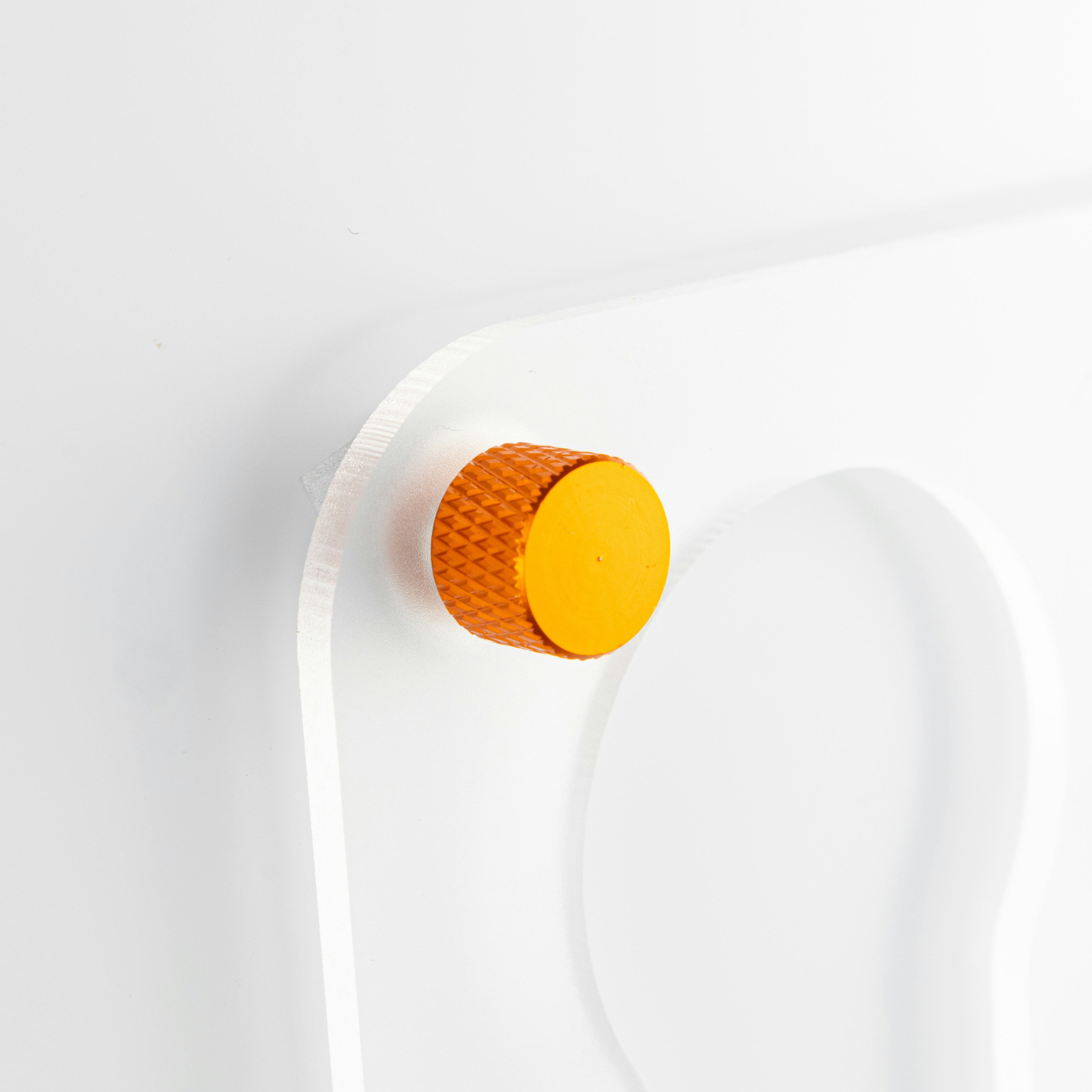 a white wall with a yellow button on it