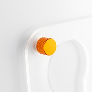 a white wall with a yellow button on it