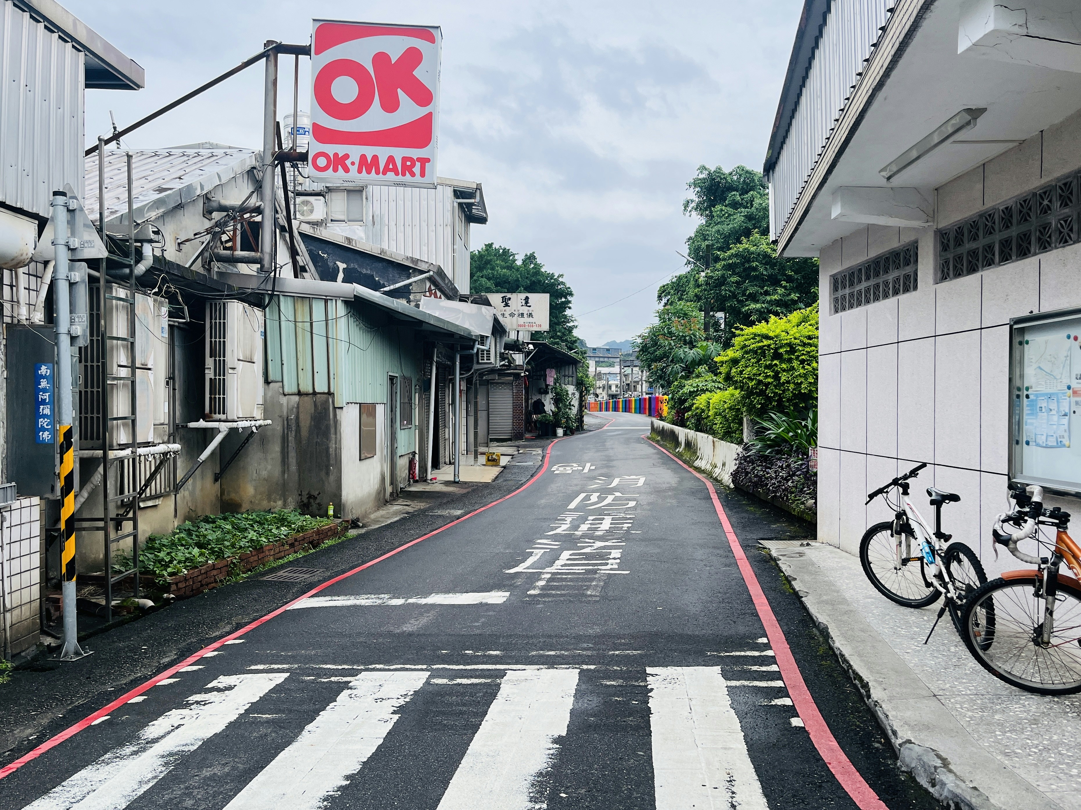 Sebuah sepeda diparkir di pinggir jalan di sebelah sebuah gedung