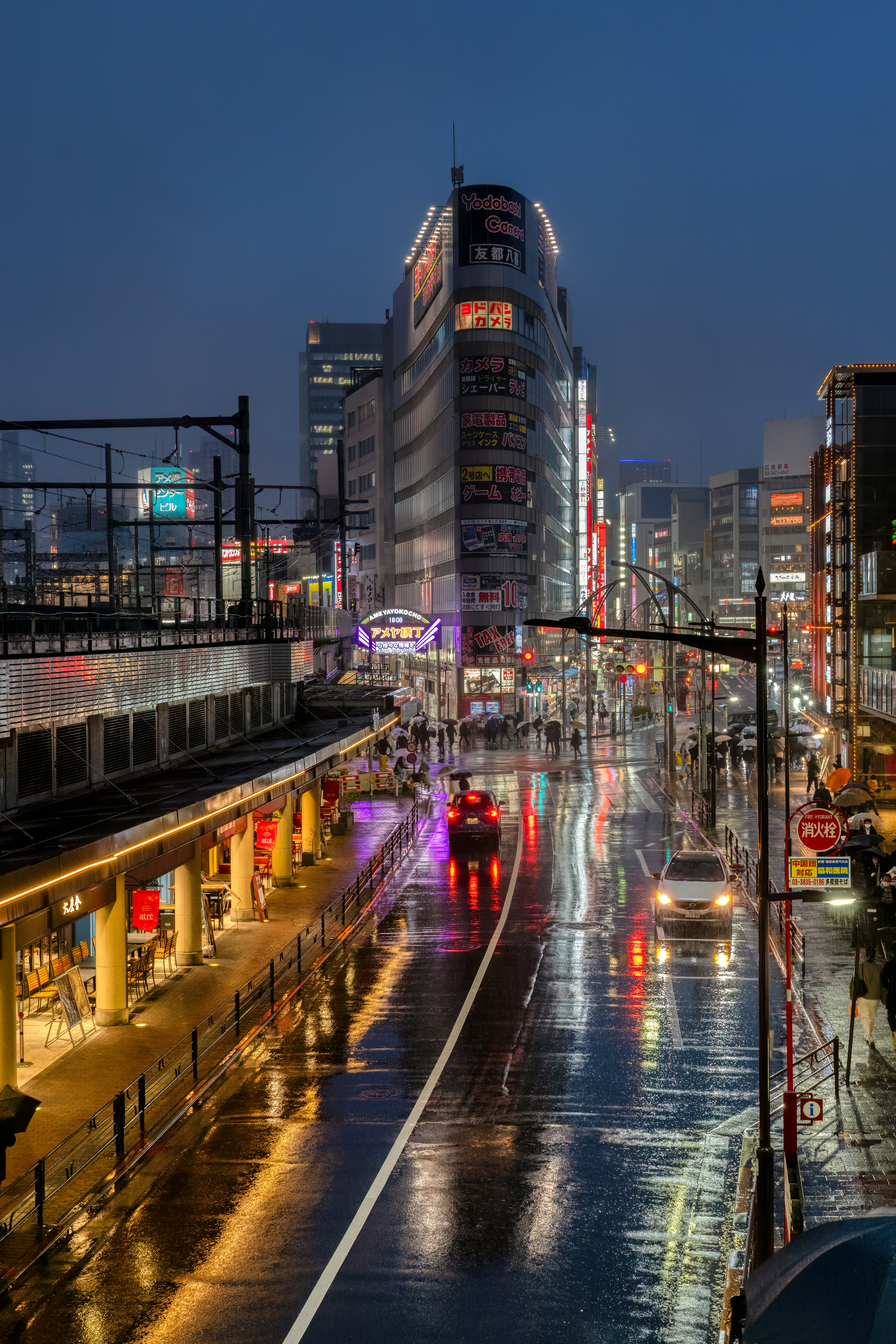 a city street at night with cars driving down it