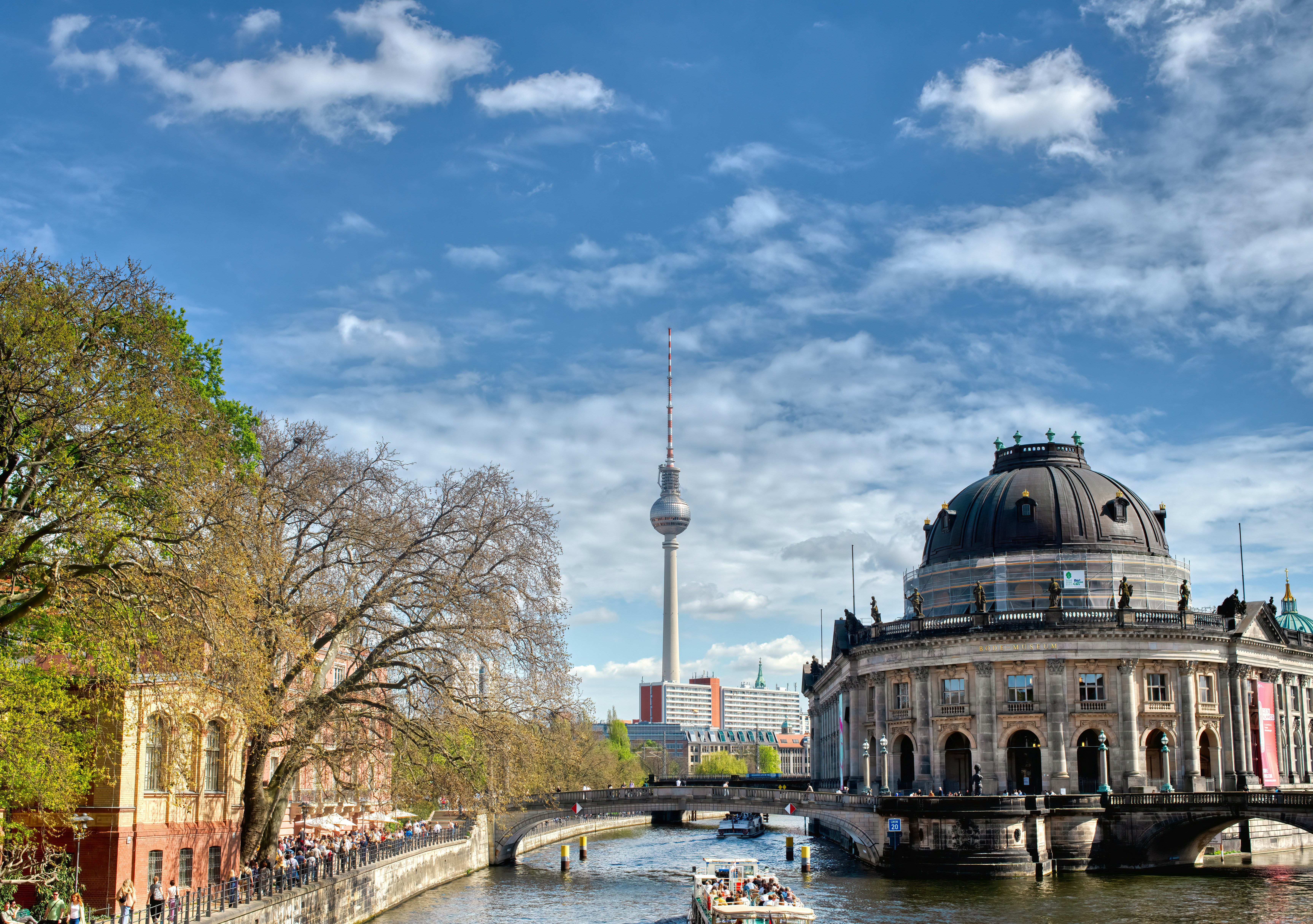 a boat traveling down a river next to a tall building