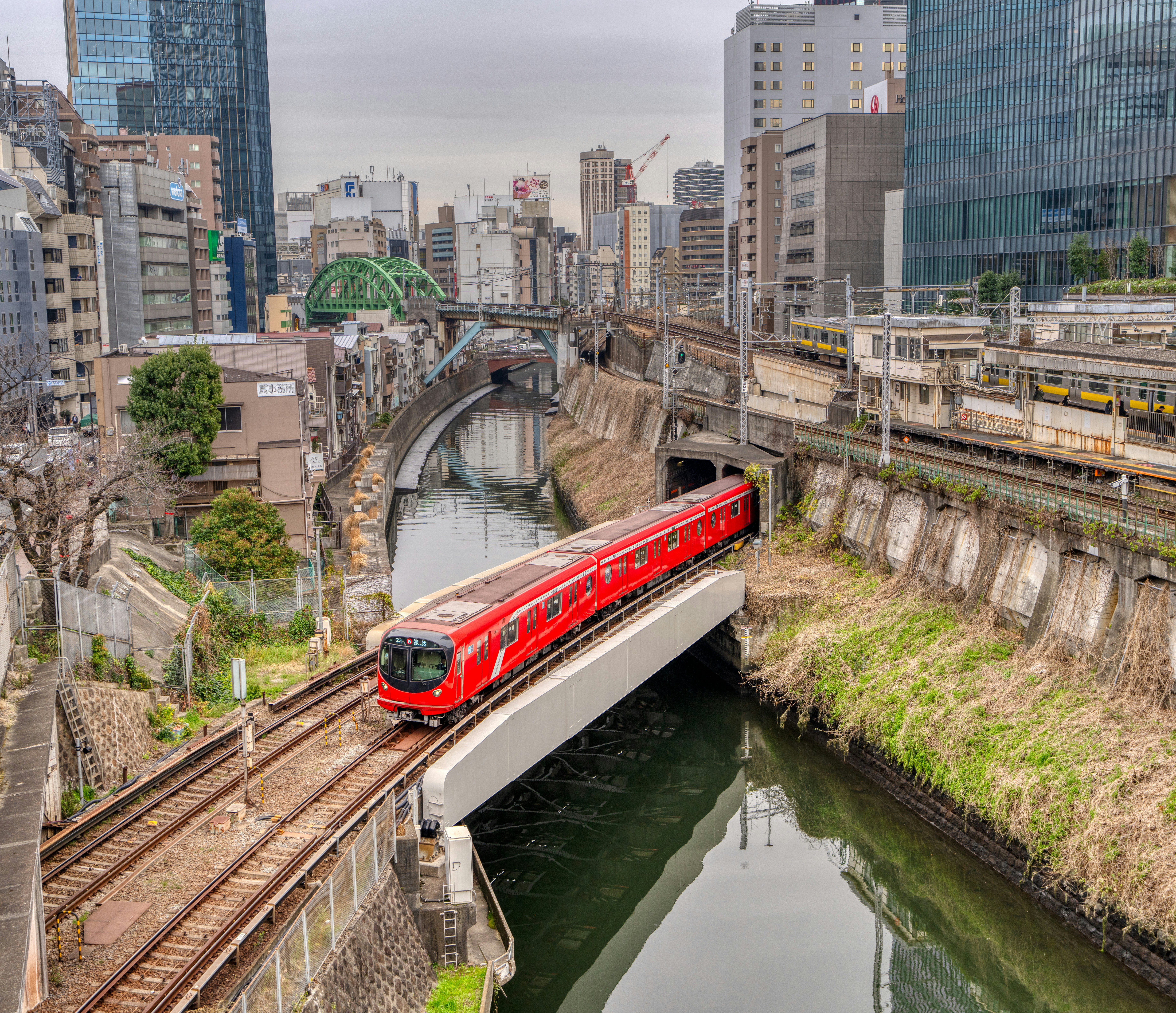 a red train traveling over a bridge over a river