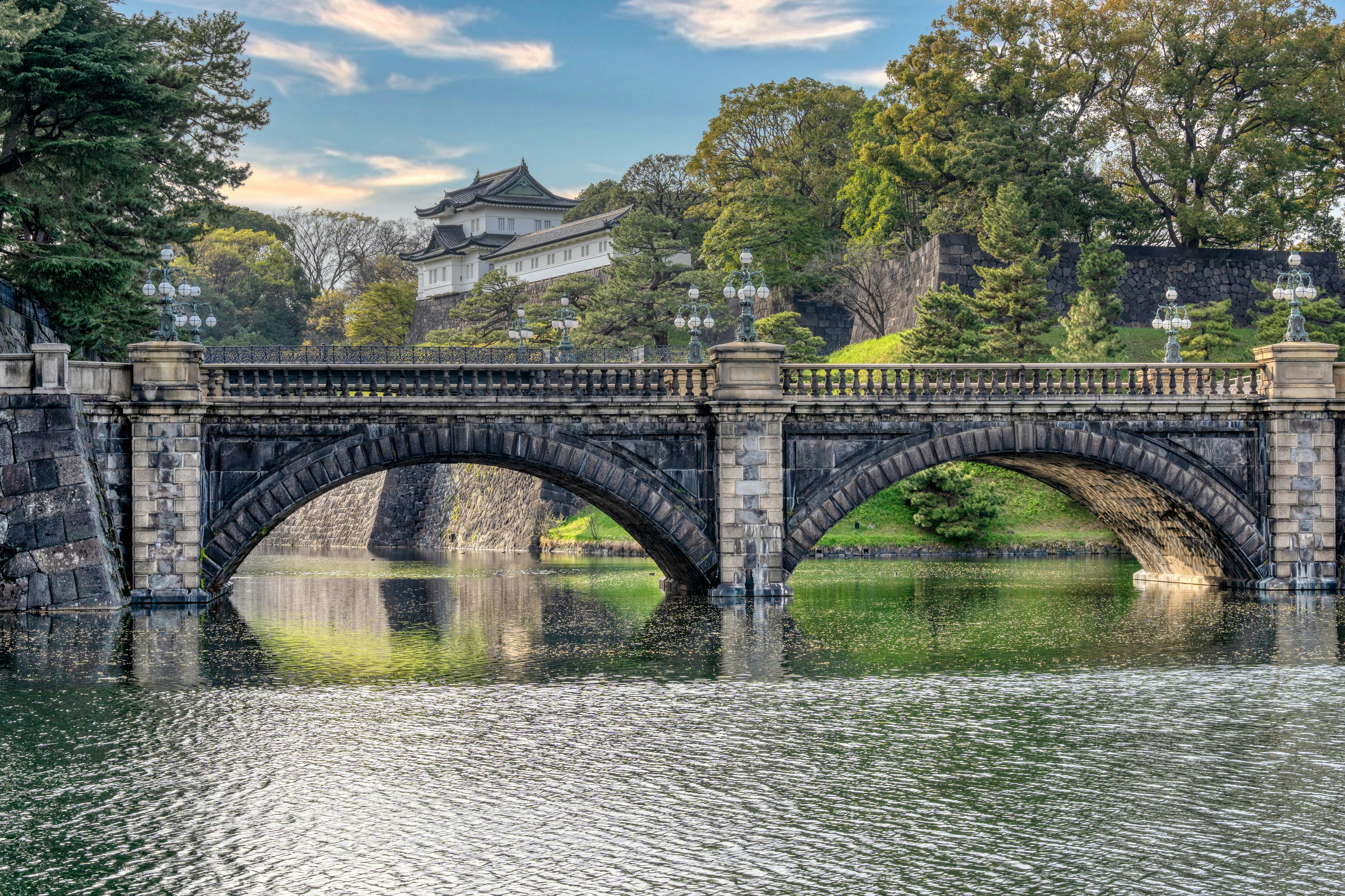a bridge over a body of water with a building in the background