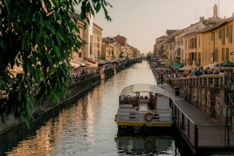 a boat traveling down a river next to tall buildings