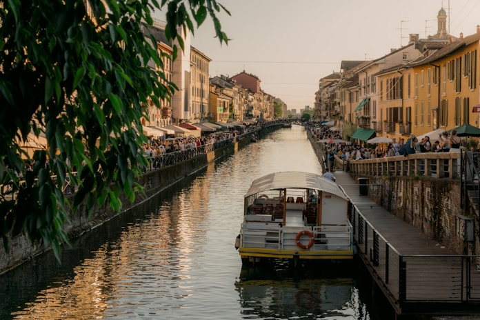 a boat traveling down a river next to tall buildings
