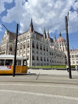 a yellow and white bus parked in front of a large building