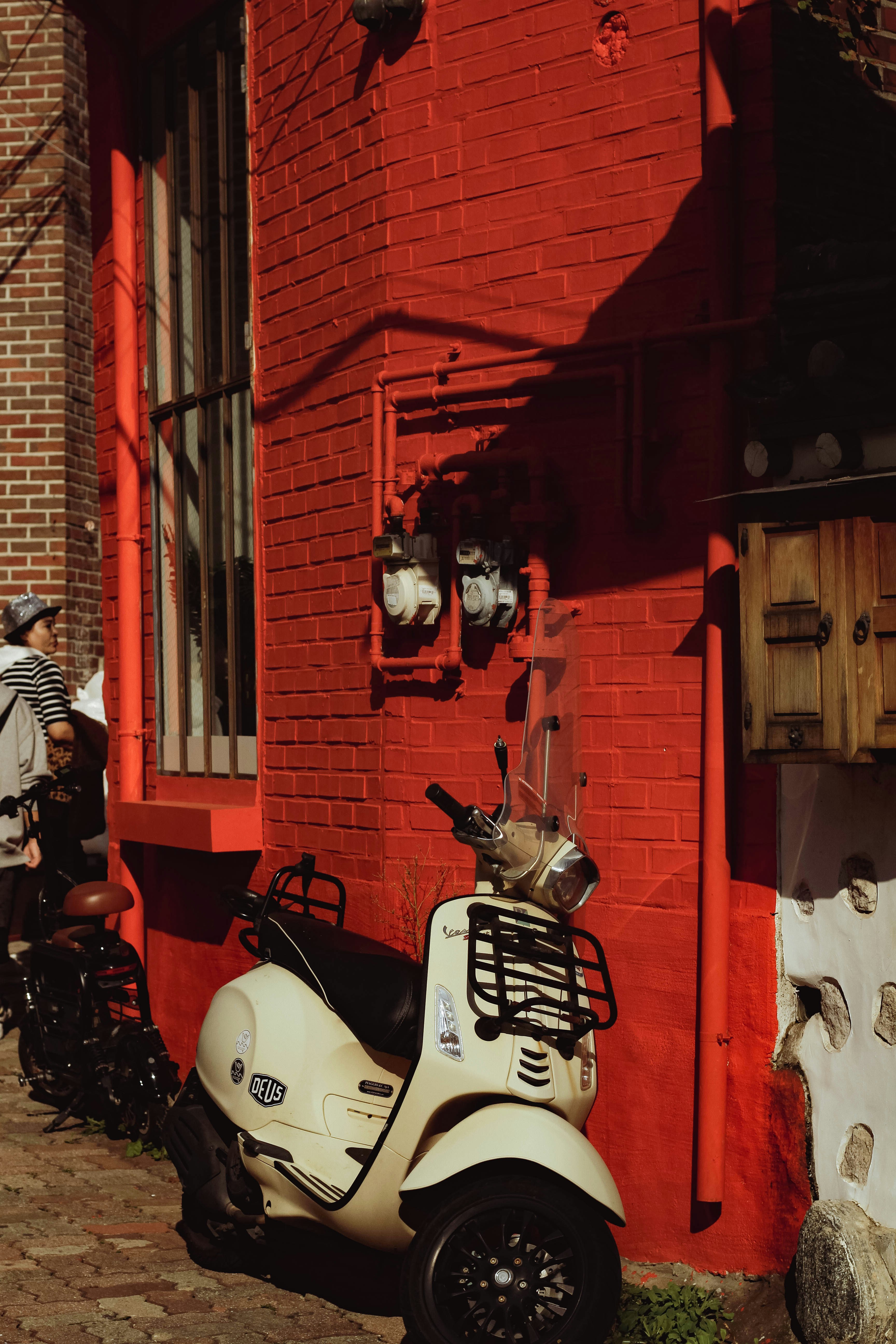 uno scooter bianco parcheggiato accanto a un edificio di mattoni rossi
