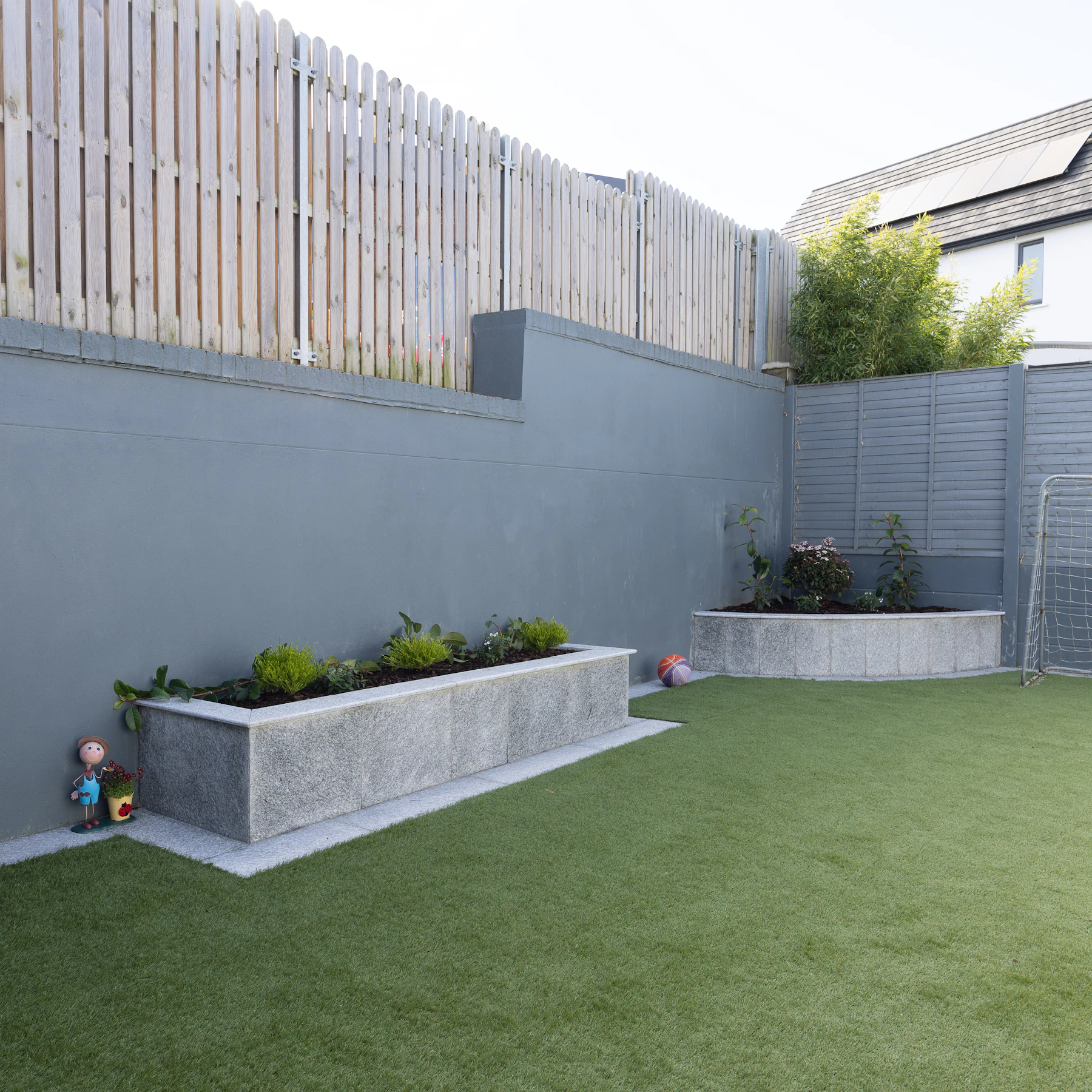 Modern backyard with artificial turf and concrete planters