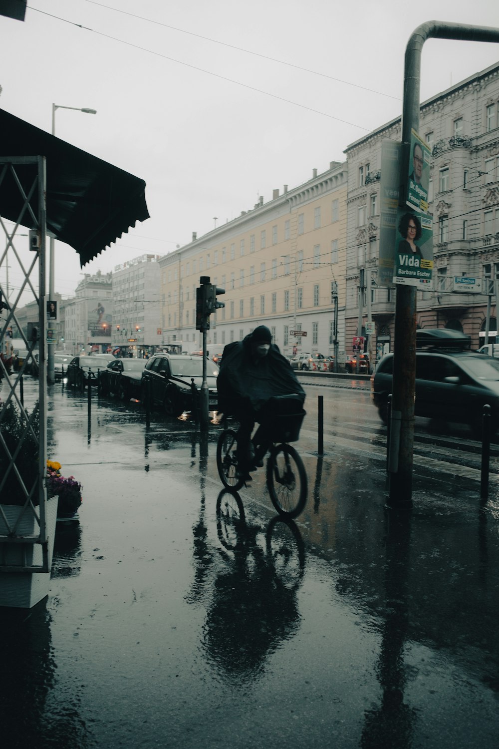 a person riding a bike down a rain soaked street