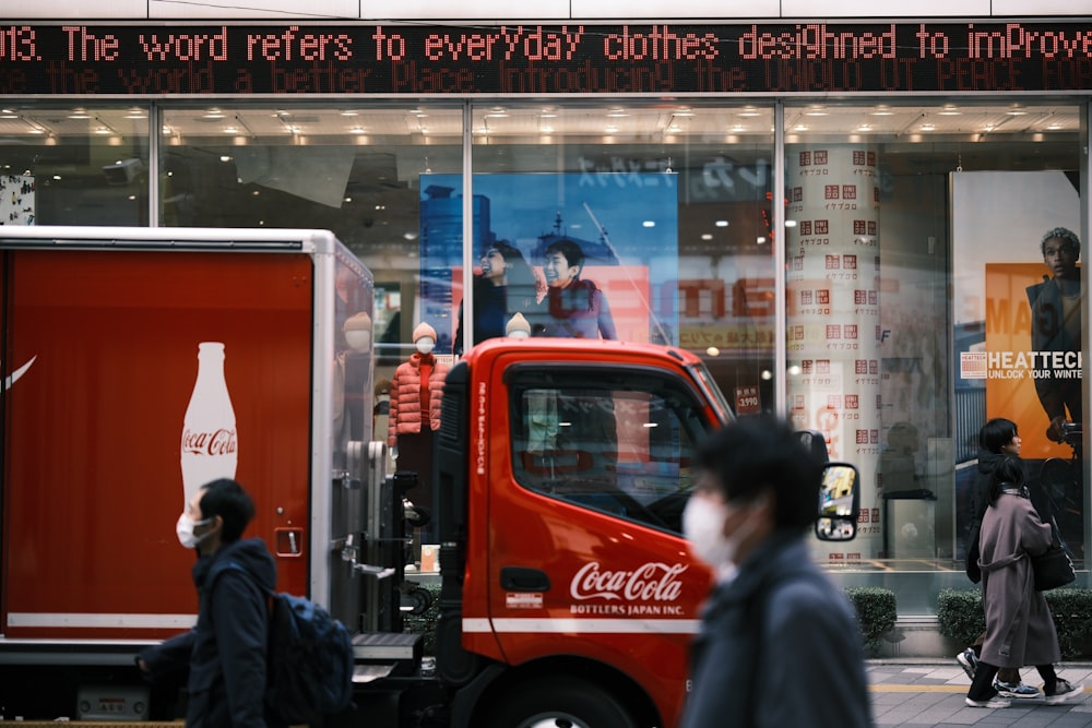 a coca cola truck is parked in front of a store