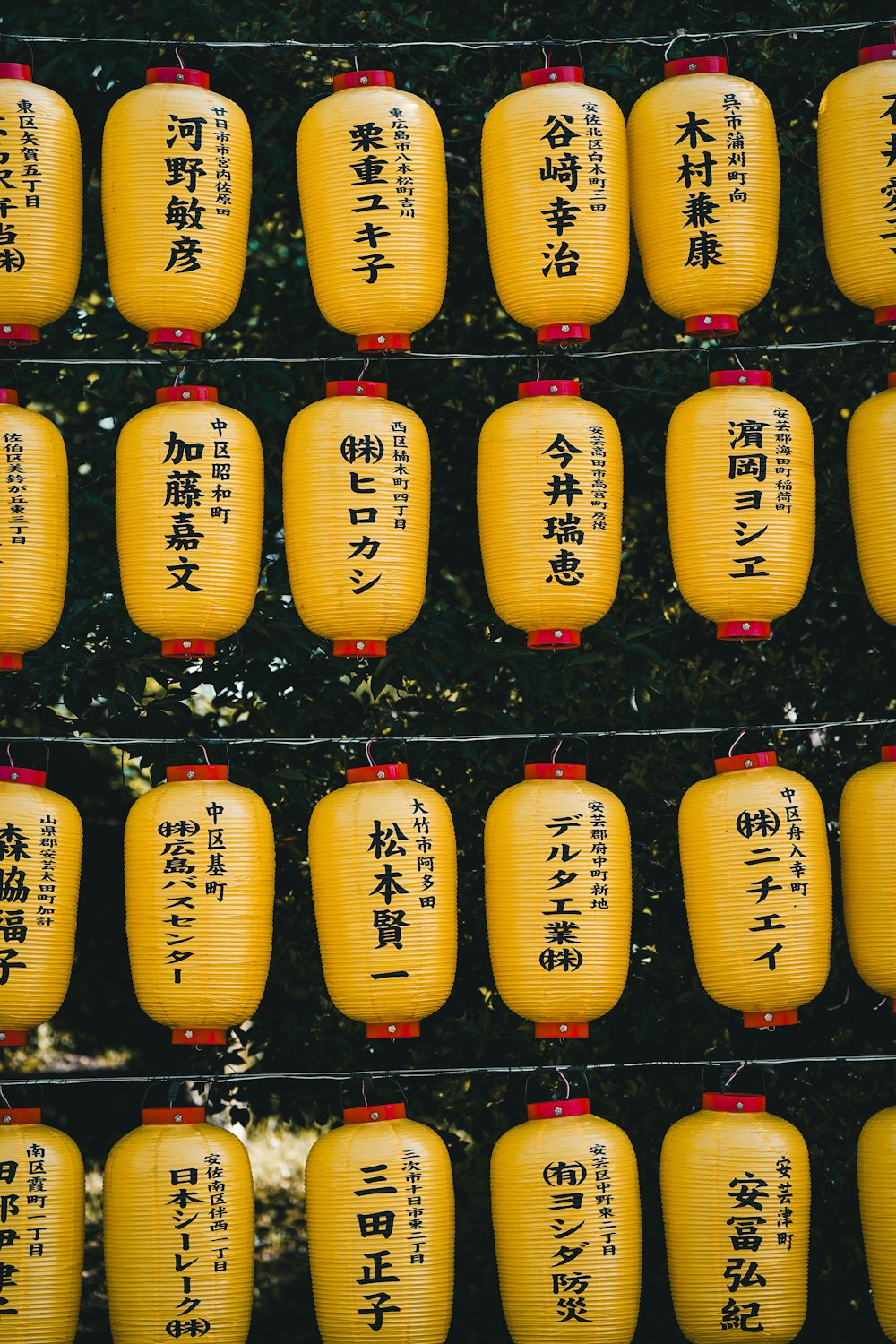 a bunch of yellow lanterns with asian writing on them