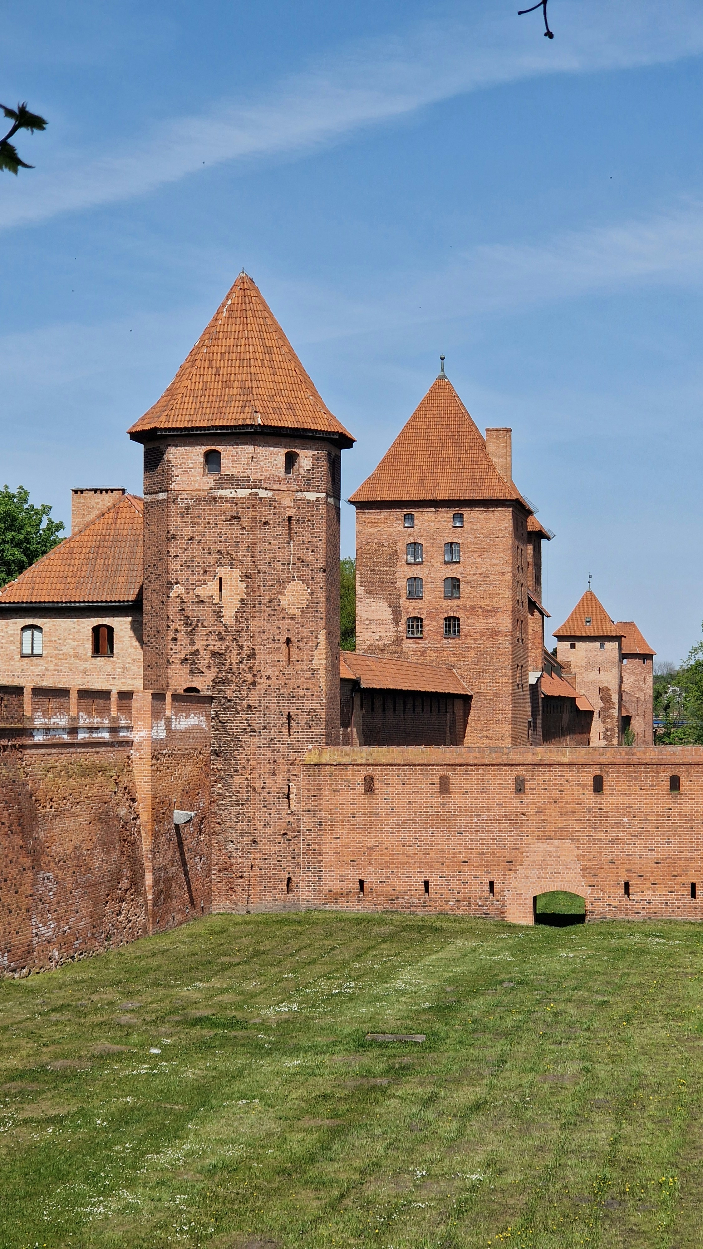 a large brick castle sitting on top of a lush green field