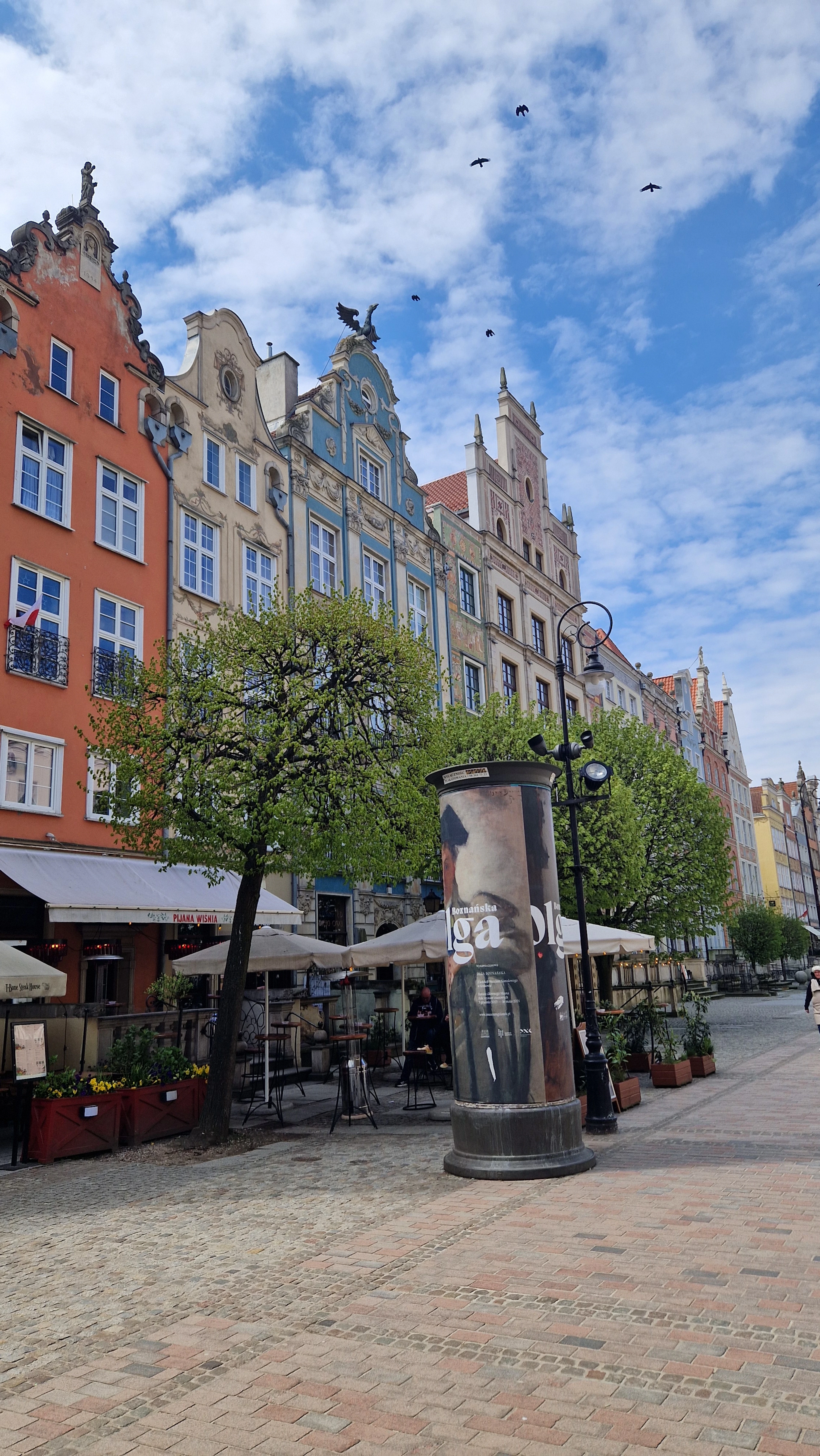 Gdansk's Long Market lined with tall painted burgher houses, cafe umbrellas set out along the cobbles