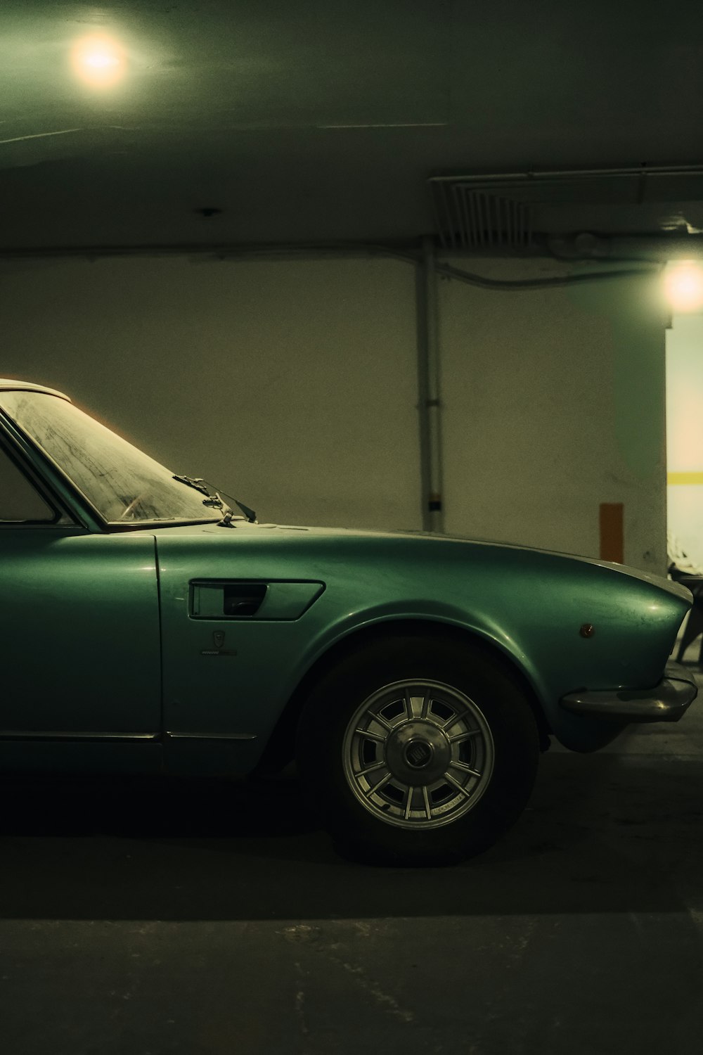 a green sports car parked in a garage