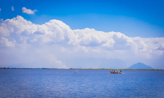 a couple of boats floating on top of a large body of water