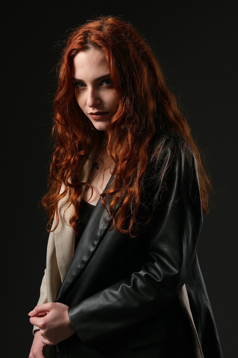 a woman with red hair wearing a black leather jacket