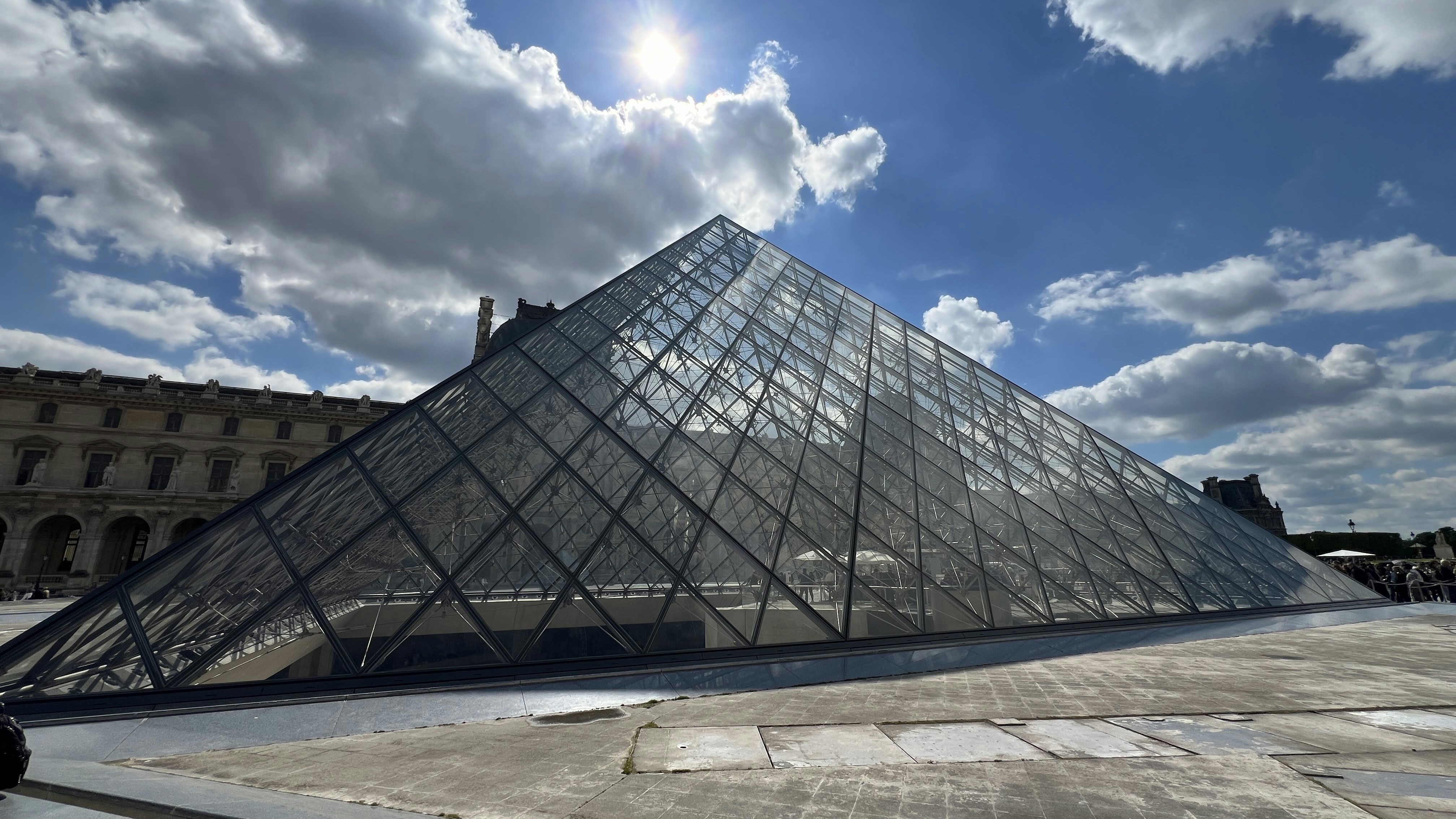 a large glass pyramid sitting in front of a building
