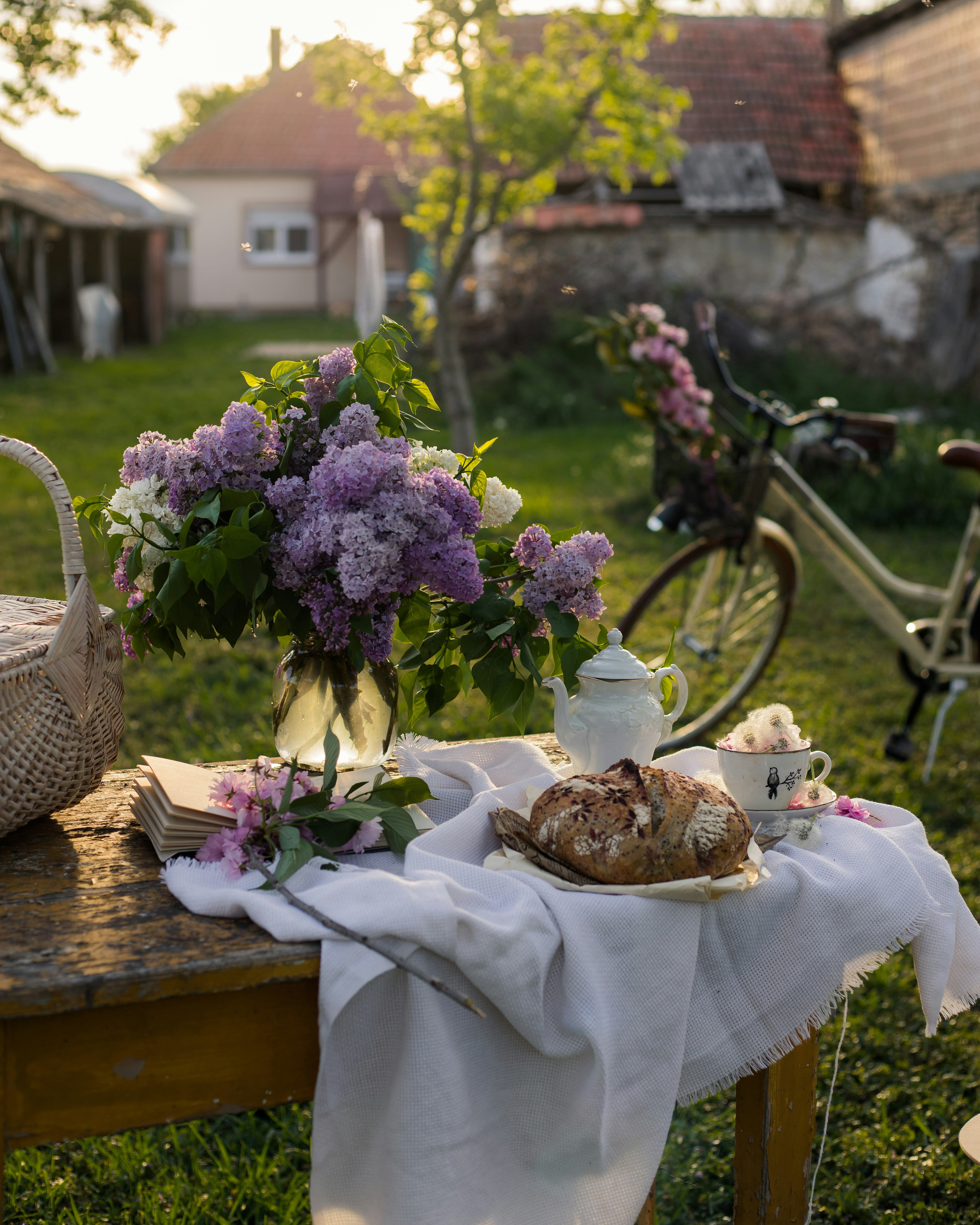 a table topped with a basket of flowers next to a bike